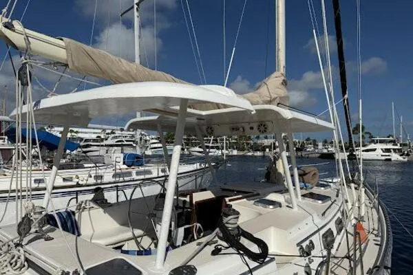 Slide: The Image of 1989 Catalina Morgan 440 sailboat docked in a marina under a clear blue sky. - 11