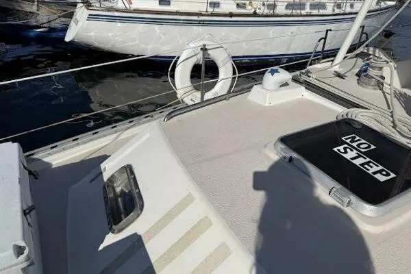 Slide: The Image of 1989 Catalina Morgan 440 yacht deck with "No Step" sign, docked near another boat. - 14