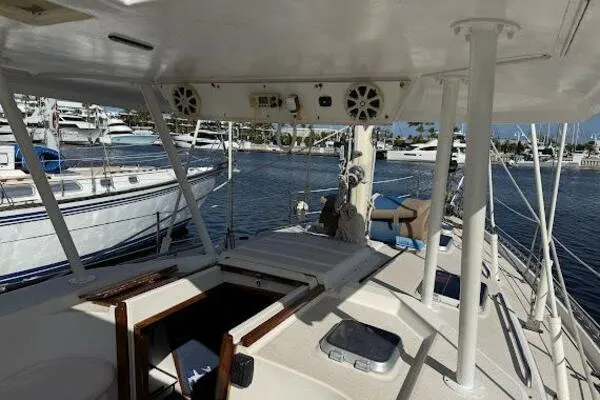 Slide: The Image of 1989 Catalina Morgan 440 sailboat docked in a marina, featuring spacious deck and cabin area. - 15