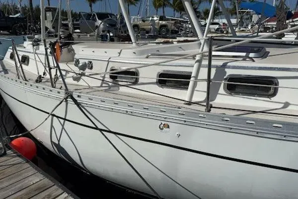 Slide: The Image of 1989 Catalina Morgan 440 sailboat docked at marina with visible rigging and portholes. - 2