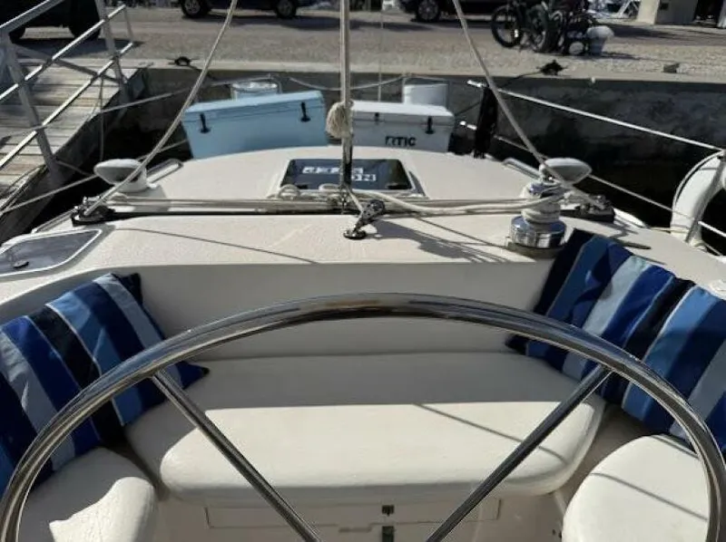 Slide: The Image of 1989 Catalina Morgan 440 sailboat cockpit with striped cushions and steering wheel. - 29