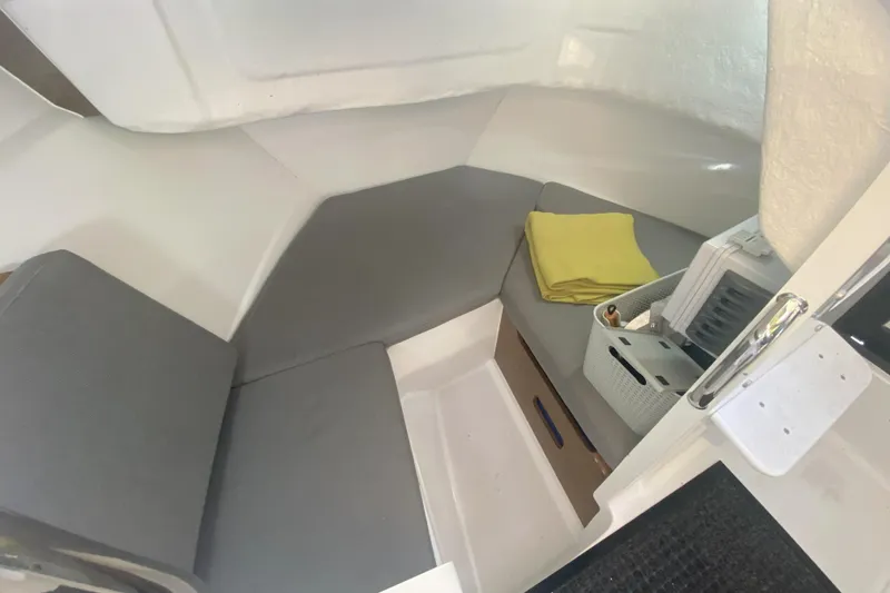 Slide: The Image of 2020 Jeanneau NC Sport 695 cabin interior with gray seating and storage. - 10