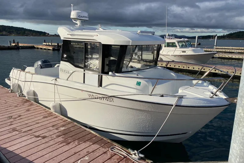 Slide: The Image of 2020 Jeanneau NC Sport 695 boat docked at marina under cloudy sky. - 2