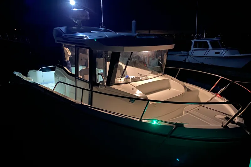 Slide: The Image of 2020 Jeanneau NC Sport 695 boat illuminated at night, docked in a marina. - 4