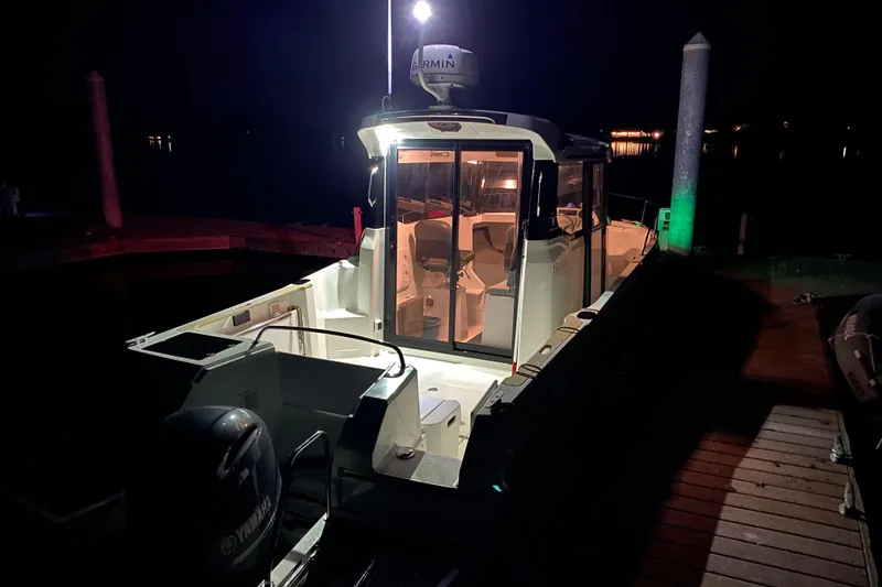 Slide: The Image of 2020 Jeanneau NC Sport 695 boat docked at night, illuminated interior. - 5