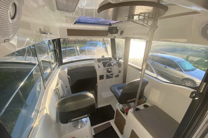 Slide: The Image of 2020 Jeanneau NC Sport 695 boat interior with steering wheel and seating. - 8