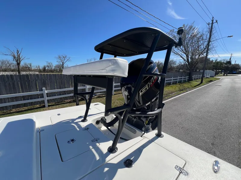 Slide: The Image of 2025 Hewes Redfisher 18 boat with elevated seat and motor on a sunny day. - 16