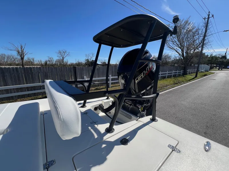 Slide: The Image of 2025 Hewes Redfisher 18 boat with Yamaha engine, parked on a sunny street. - 17