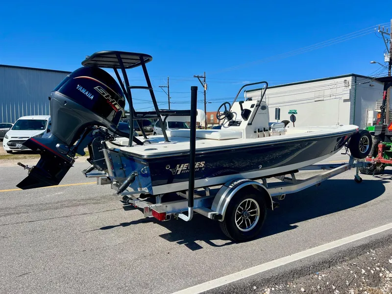 Slide: The Image of 2025 Hewes Redfisher 18 boat on trailer with Yamaha outboard motor, parked on street. - 4