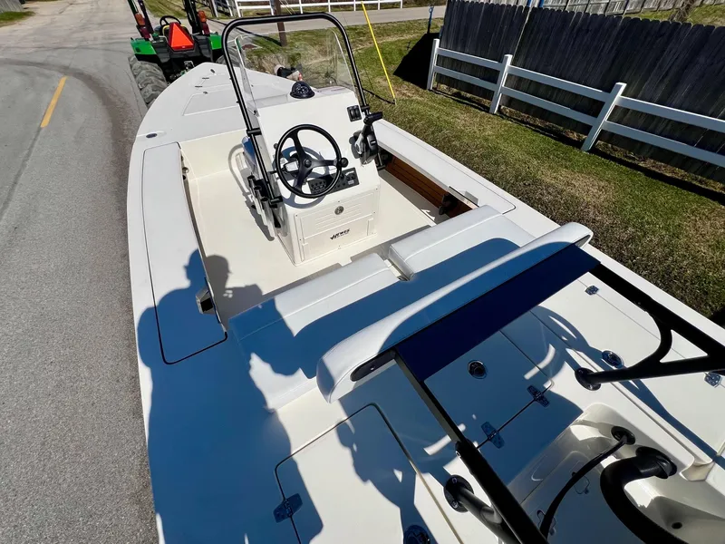 Slide: The Image of 2025 Hewes Redfisher 18 boat on road, featuring steering console and seating. - 8