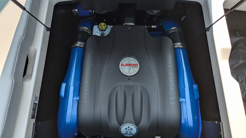 Slide: The Image of 2025 MasterCraft NXT23 Ilmor engine with blue accents in boat compartment. - 15