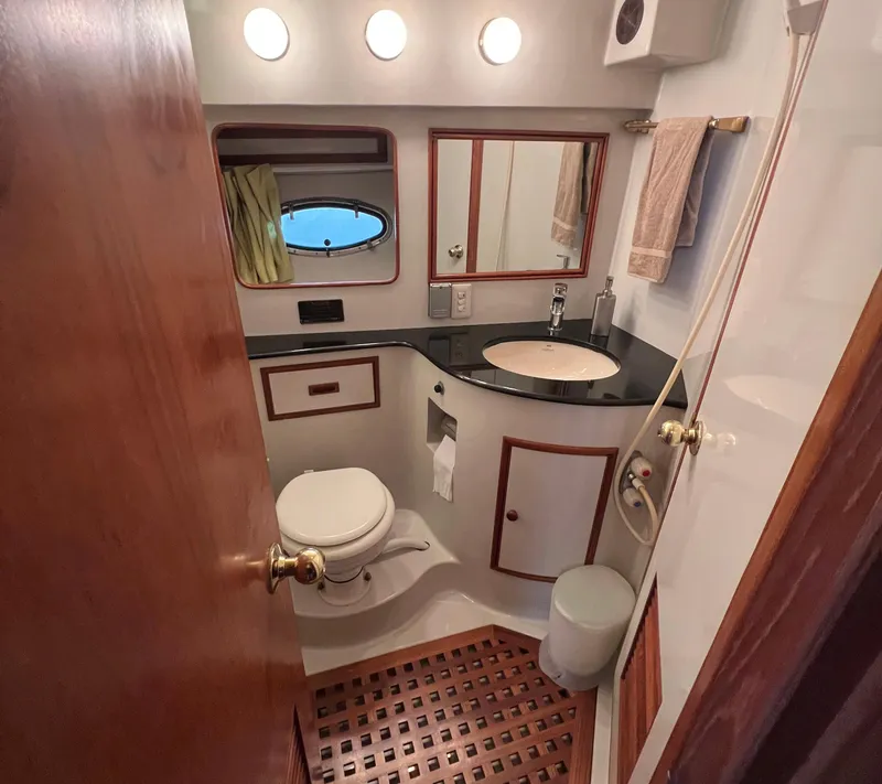 Slide: The Image of Bathroom interior of a 1988 President Motor Yacht, featuring sink, toilet, and mirror. - 13