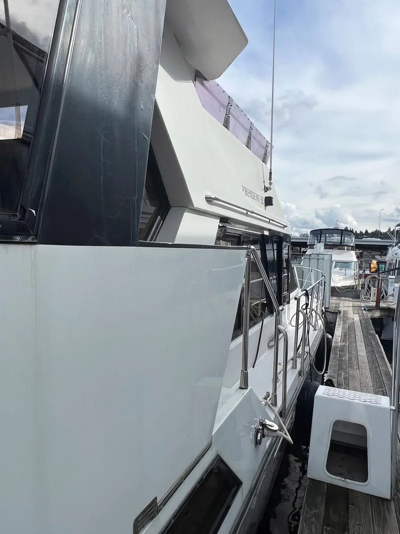 Slide: The Image of 1988 President Motor Yacht docked at marina, side view with clear skies. - 16