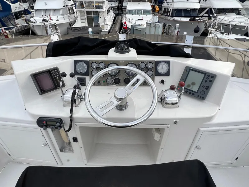 Slide: The Image of 1988 President Motor Yacht helm with steering wheel, navigation instruments, and control panels. - 17
