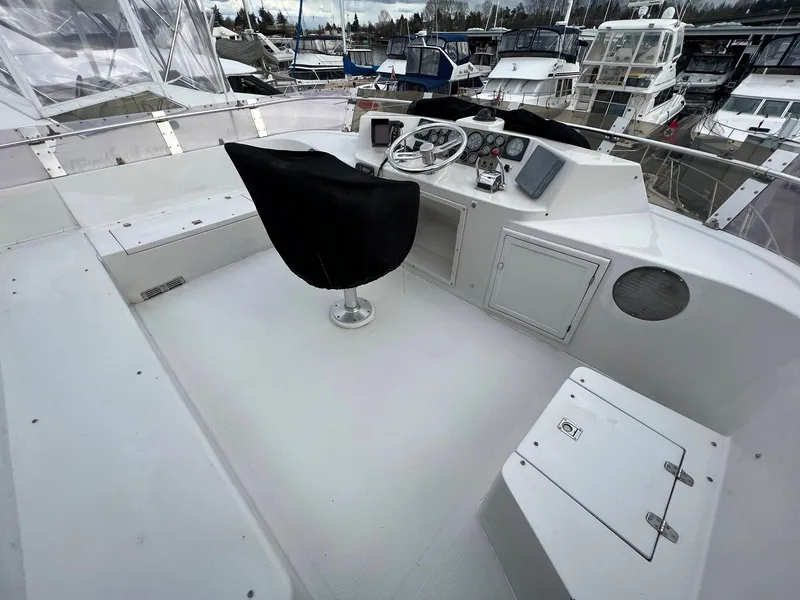 Slide: The Image of 1988 President Motor Yacht helm with covered seat, docked among other boats. - 18