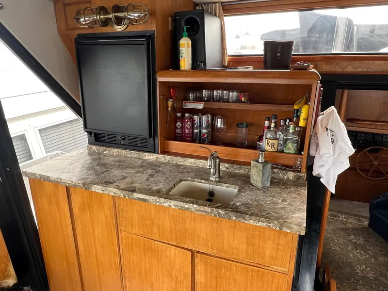 Slide: The Image of 1988 President Motor Yacht interior with bar, sink, and wooden cabinetry. - 19