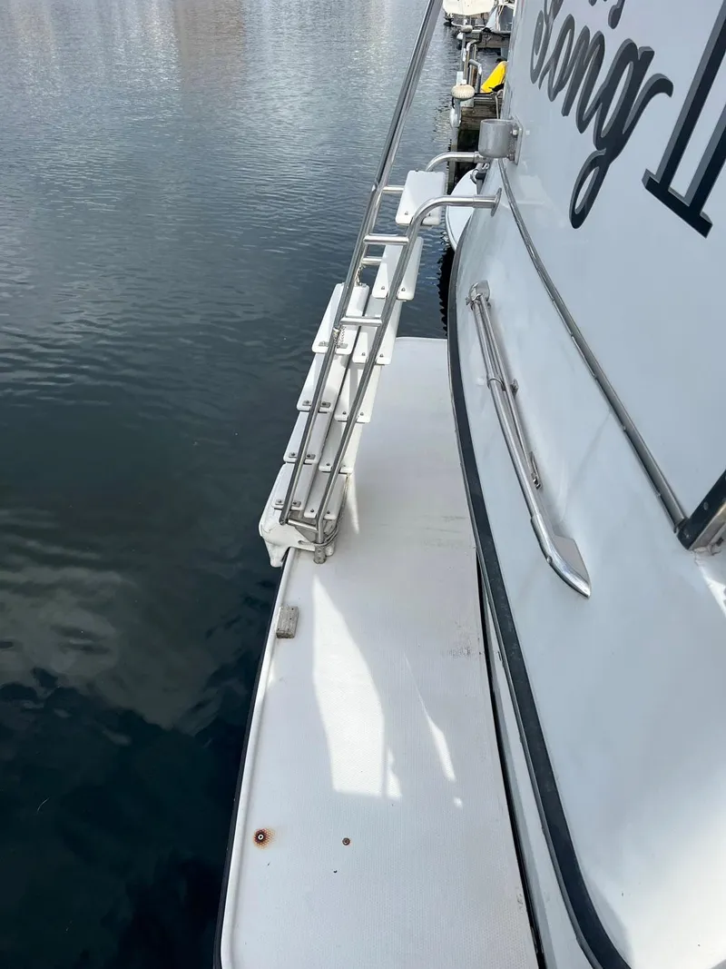 Slide: The Image of 1988 President Motor Yacht, side view with railing and water reflection. - 23