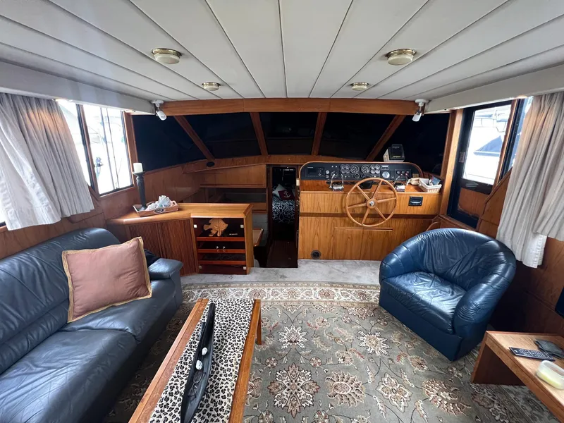 Slide: The Image of 1988 President Motor Yacht interior with leather seating, wooden helm, and nautical decor. - 3