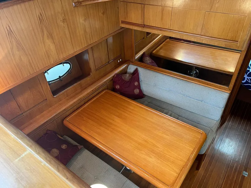 Slide: The Image of Interior of 1988 President Motor Yacht with wooden dining area and cushioned seating. - 5