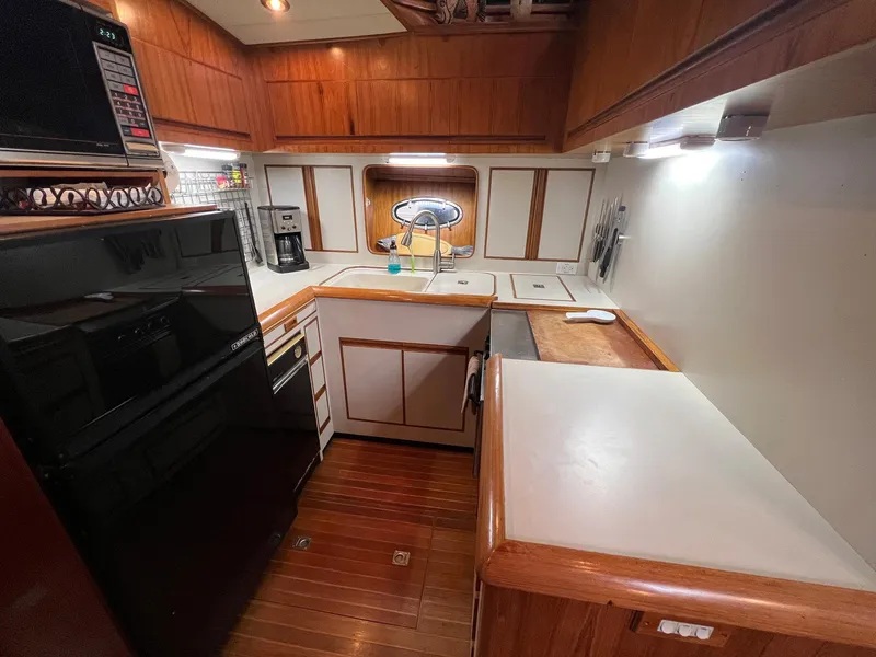 Slide: The Image of 1988 President Motor Yacht kitchen with wood cabinetry, modern appliances, and ample counter space. - 6