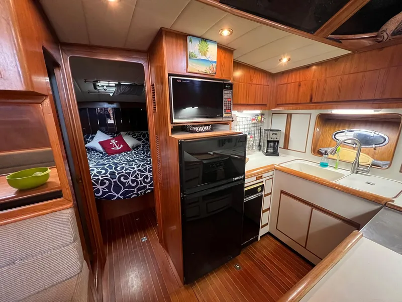Slide: The Image of 1988 President Motor Yacht interior with cozy bedroom, modern kitchen, and wooden finishes. - 8