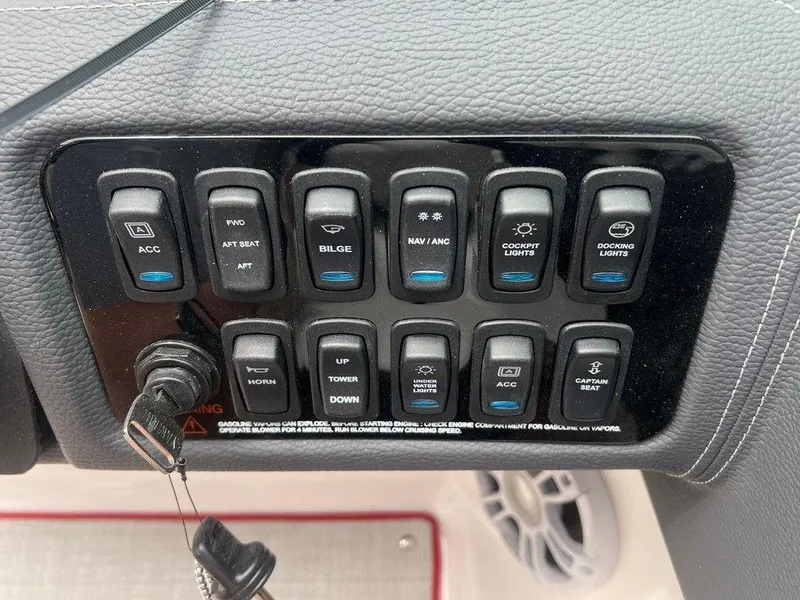 Slide: The Image of Control panel of 2024 Regal LX4 boat with various switches and key ignition. - 12