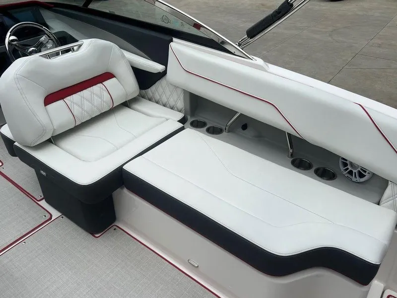 Slide: The Image of 2024 Regal LX4 boat interior with white and red seating, cup holders, and steering wheel. - 7