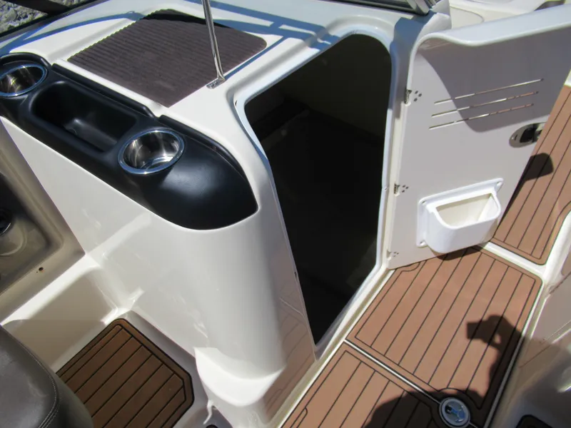 Slide: The Image of 2014 Yamaha Boats 242 Limited interior with open storage compartment and cup holders. - 14
