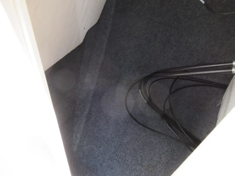 Slide: The Image of Carpeted interior space with cables, possibly inside a 2014 Yamaha Boats 242 Limited. - 17