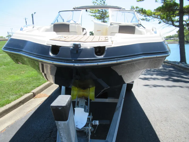 Slide: The Image of 2014 Yamaha Boats 242 Limited on trailer, parked near water. - 6