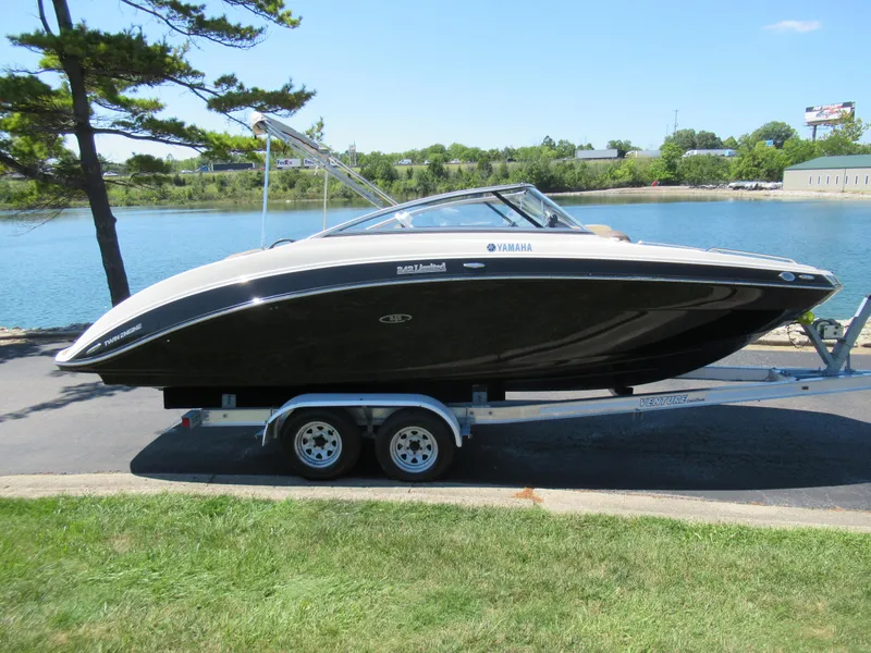 Slide: The Image of 2014 Yamaha Boats 242 Limited on trailer by a lake. - 9
