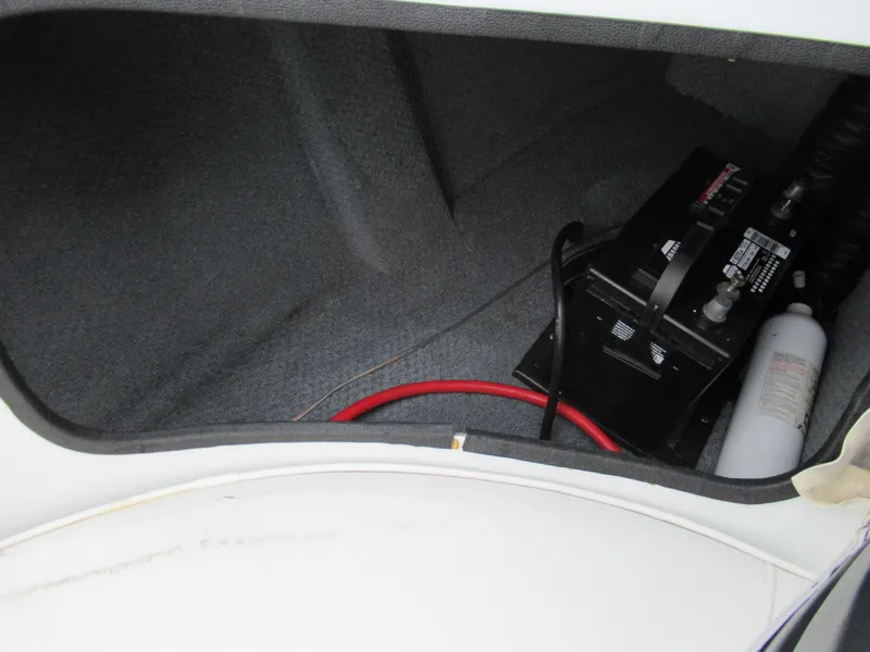 Slide: The Image of 2000 Moomba Outback LS boat storage compartment with battery and fire extinguisher. - 16
