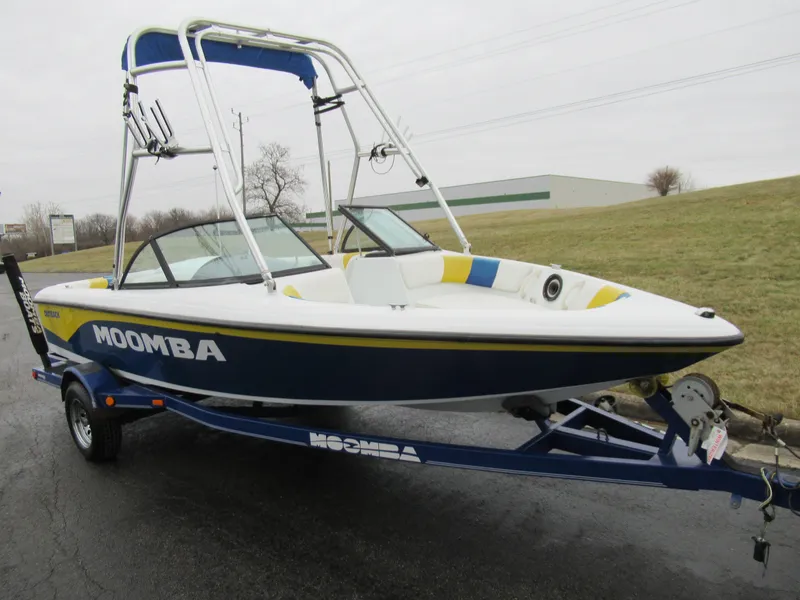 Slide: The Image of 2000 Moomba Outback LS boat on trailer, blue and white design, parked outdoors. - 5