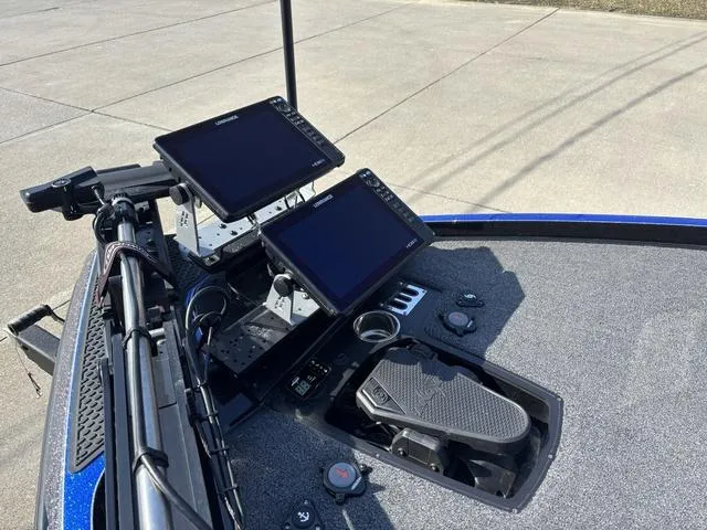 Slide: The Image of 2024 Ranger Z520R boat with spacious deck and dual seats, parked outdoors. - 11