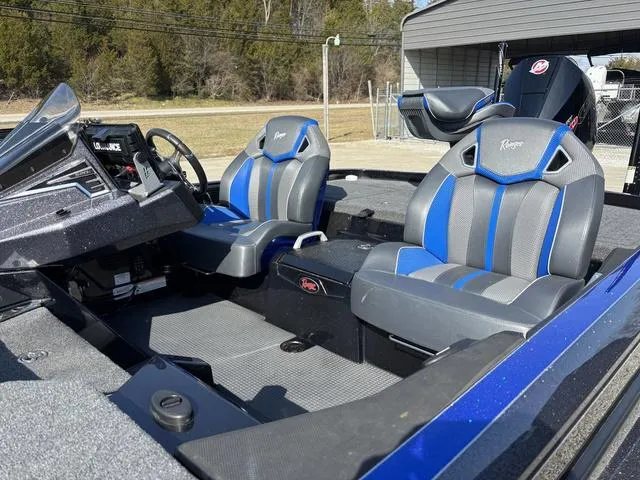 Slide: The Image of 2024 Ranger Z520R boat interior with blue and gray seats, steering console, and dashboard. - 13