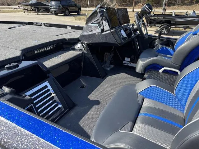 Slide: The Image of 2024 Ranger Z520R boat interior with blue and gray seating, modern dashboard, and steering wheel. - 16