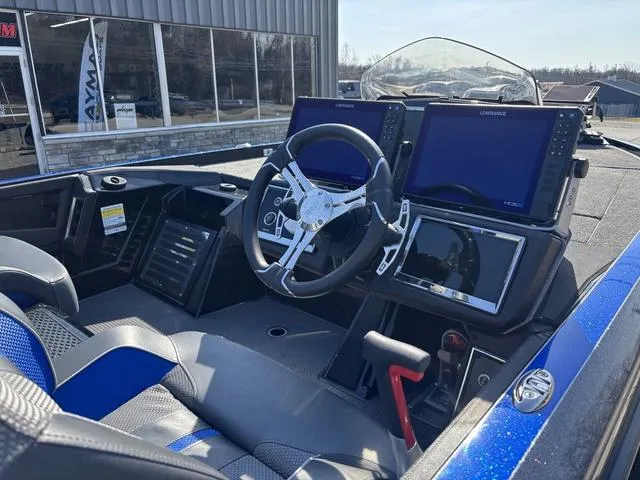 Slide: The Image of 2024 Ranger Z520R boat with spacious deck, parked outside a showroom on a sunny day. - 5