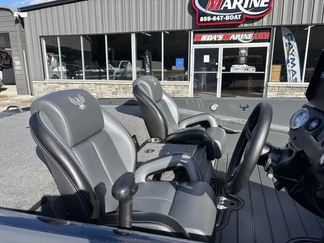 Slide: The Image of 2024 Phoenix 921 Elite II boat interior with gray seating at a marine dealership. - 7