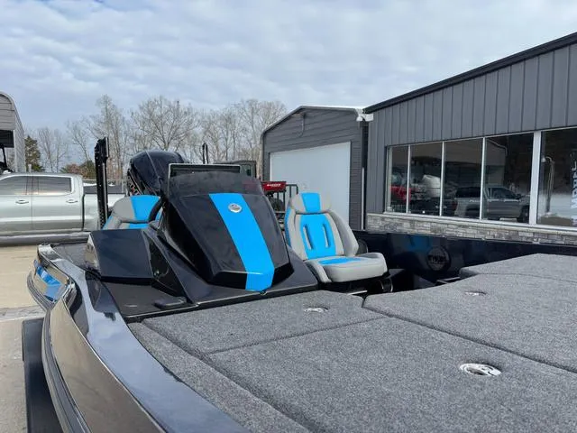 Slide: The Image of 2025 iKon LX20 boat with blue accents, parked near a building under a cloudy sky. - 12