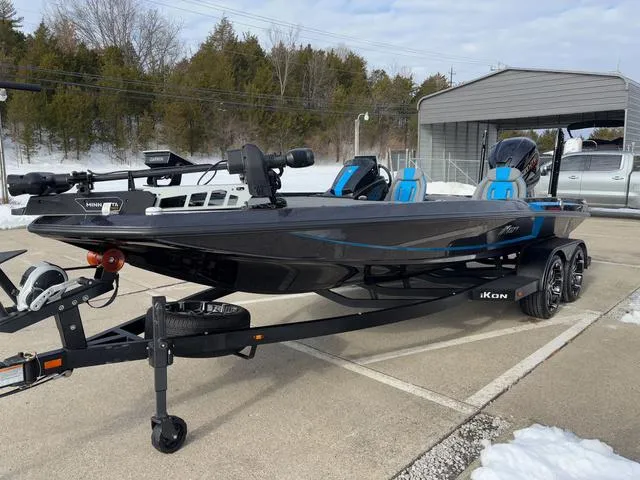 Slide: The Image of 2025 iKon LX20 boat on trailer, black with blue accents, parked outdoors. - 16