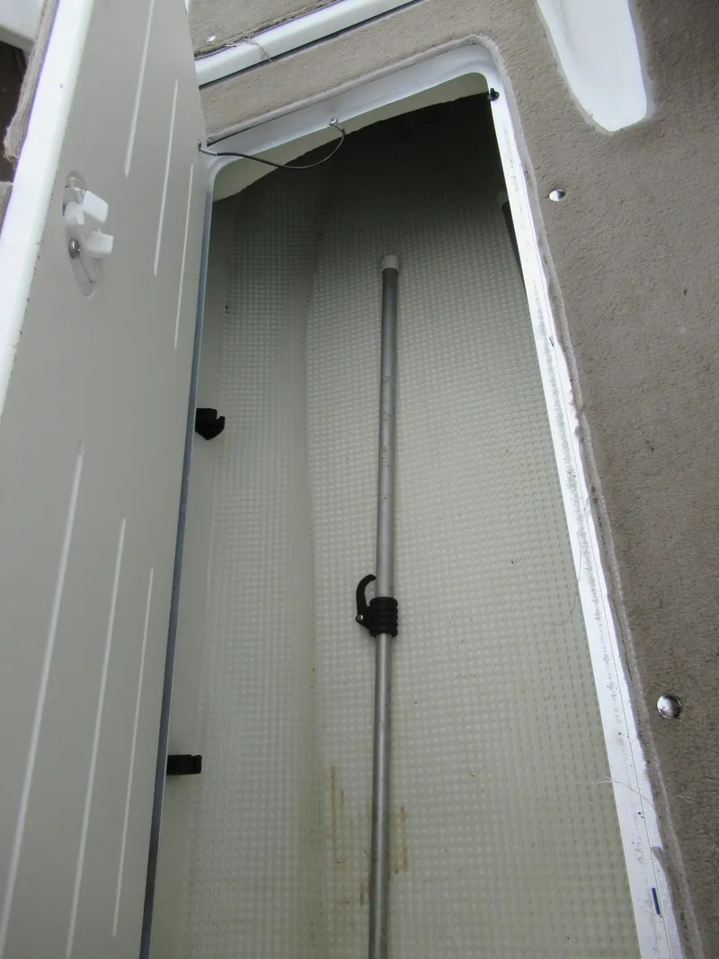 Slide: The Image of Storage compartment in a 2009 Azure AZ208 boat, featuring a long metal rod. - 16