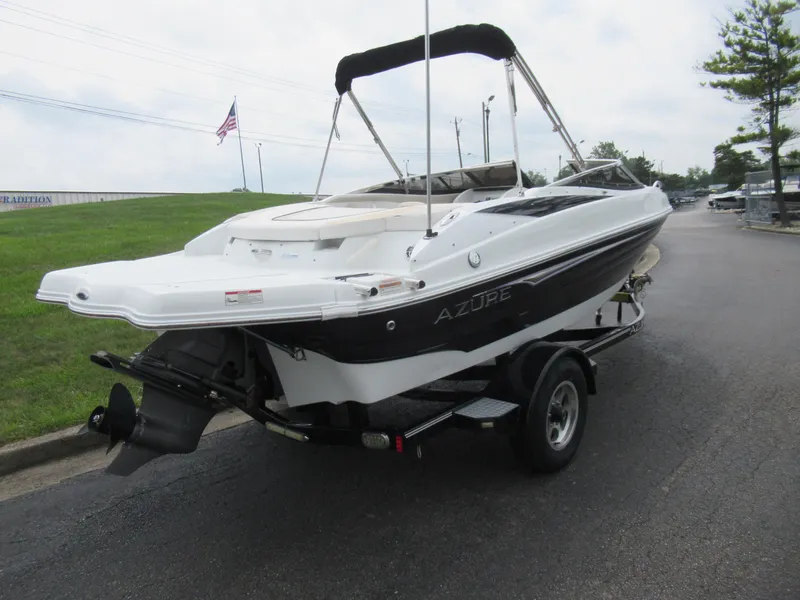 Slide: The Image of 2009 Azure AZ208 boat on trailer, parked on road with American flag in background. - 3