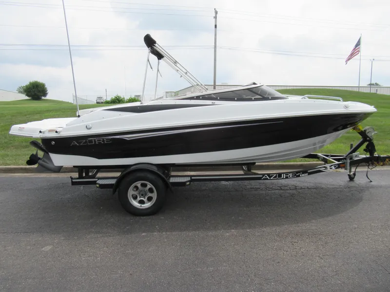 Slide: The Image of 2009 Azure AZ208 boat on trailer, parked on road with American flag in background. - 4