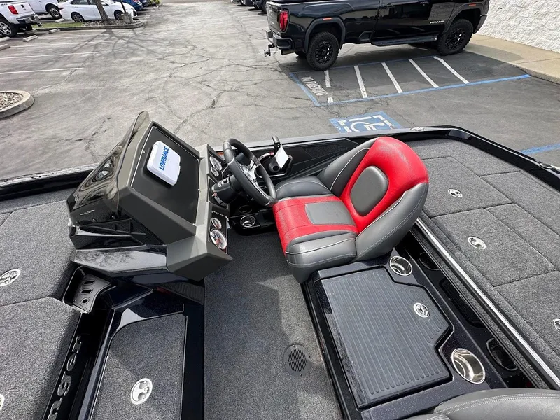 Slide: The Image of 2024 Ranger Z518 boat interior with red and gray seating, steering console, and storage compartments. - 15