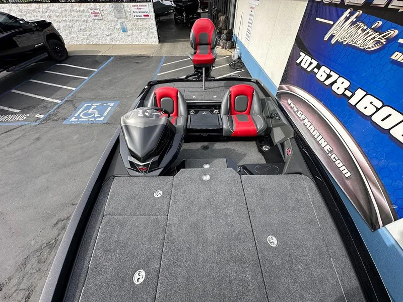 Slide: The Image of 2024 Ranger Z518 boat with red and black seats, parked near a building. - 23