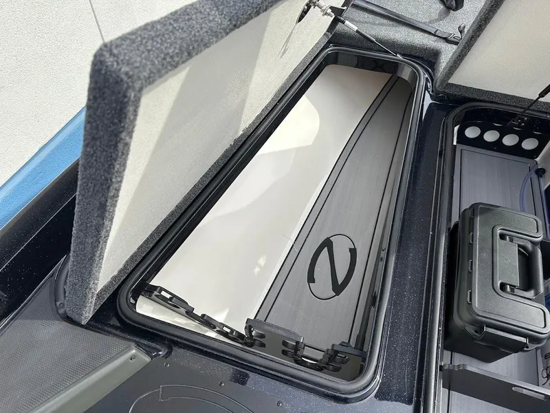 Slide: The Image of 2024 Ranger Z518 boat storage compartment with open lid and organized interior. - 26