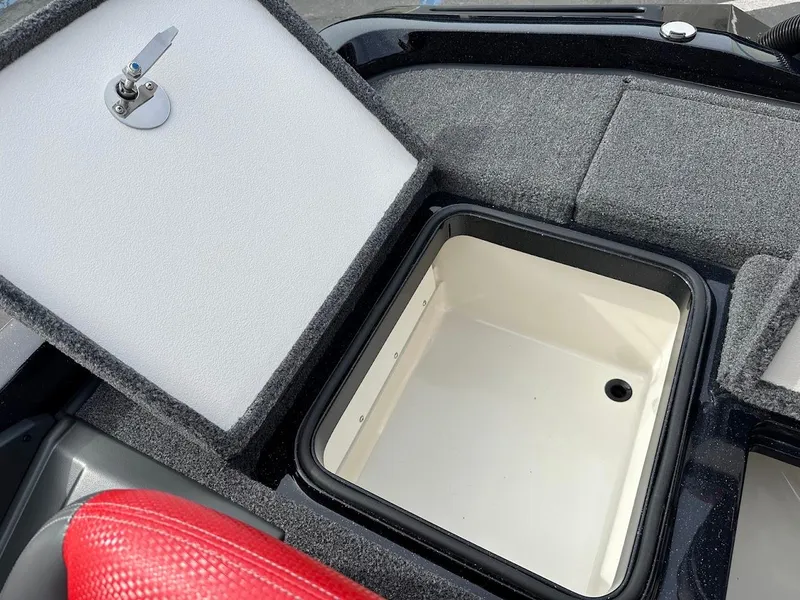 Slide: The Image of 2024 Ranger Z518 boat storage compartment with open lid, featuring gray and red interior. - 34