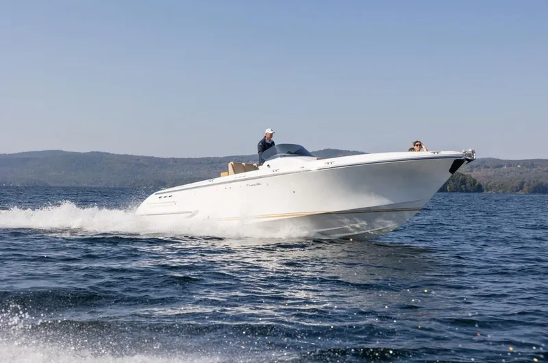 Slide: The Image of 2022 Comitti Isola I-33 speedboat cruising on a lake with scenic mountain backdrop. - 1