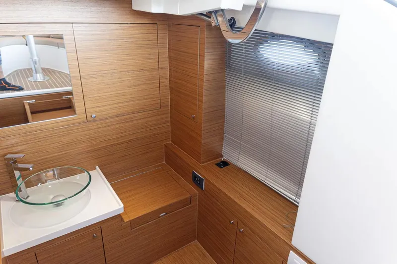 Slide: The Image of 2022 Comitti Isola I-33 yacht interior with modern wood finish and glass sink. - 13