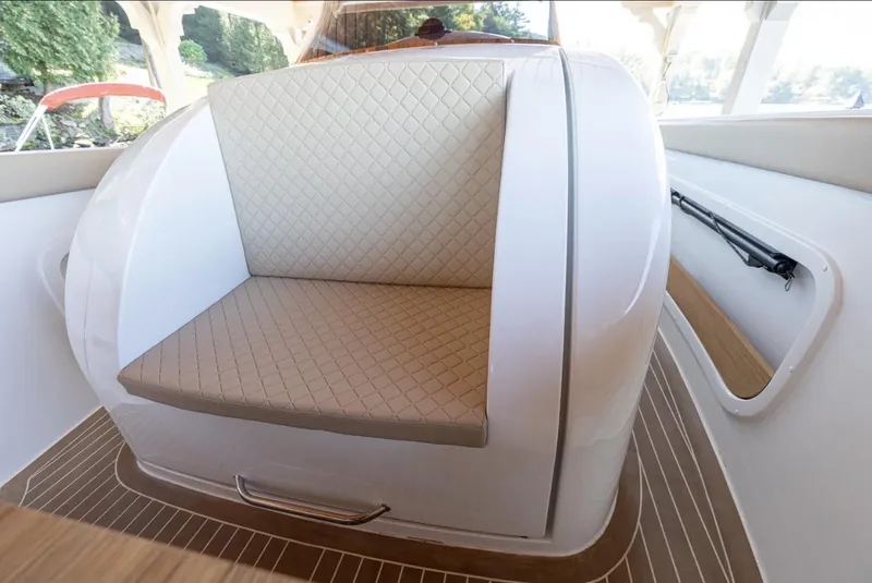 Slide: The Image of 2022 Comitti Isola I-33 boat interior with cushioned seating and wood flooring. - 15